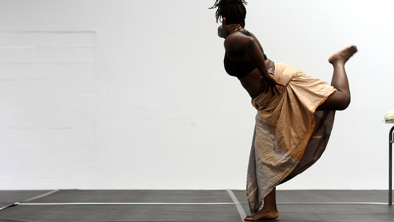 Kaïsha Essiane wrapped into a blanket, jumping.