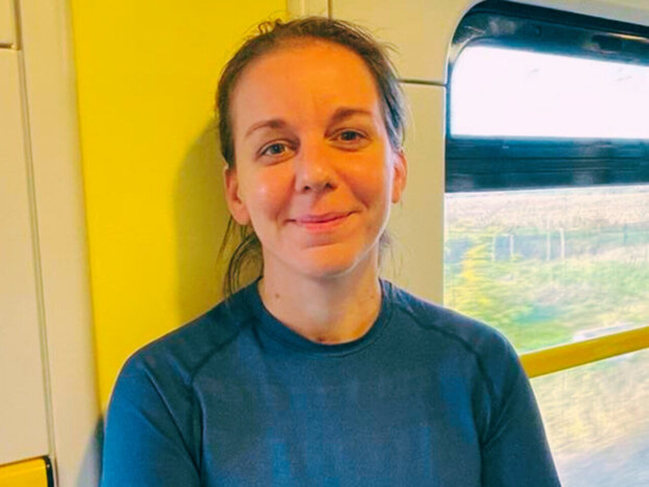Fanni Somlyai leaning against the wall in the hallway of a train