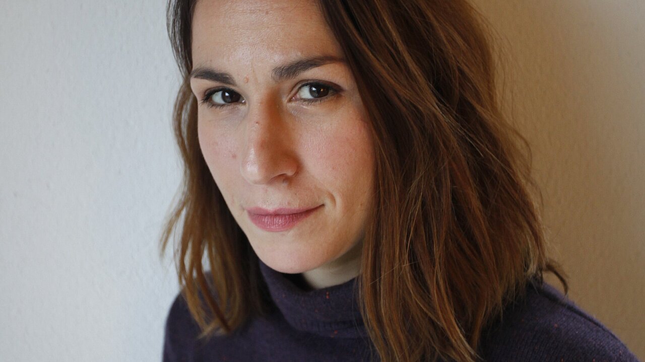 Portrait of Bojana Robinson, wearing a black jumper, long dark hair touching her shoulders.