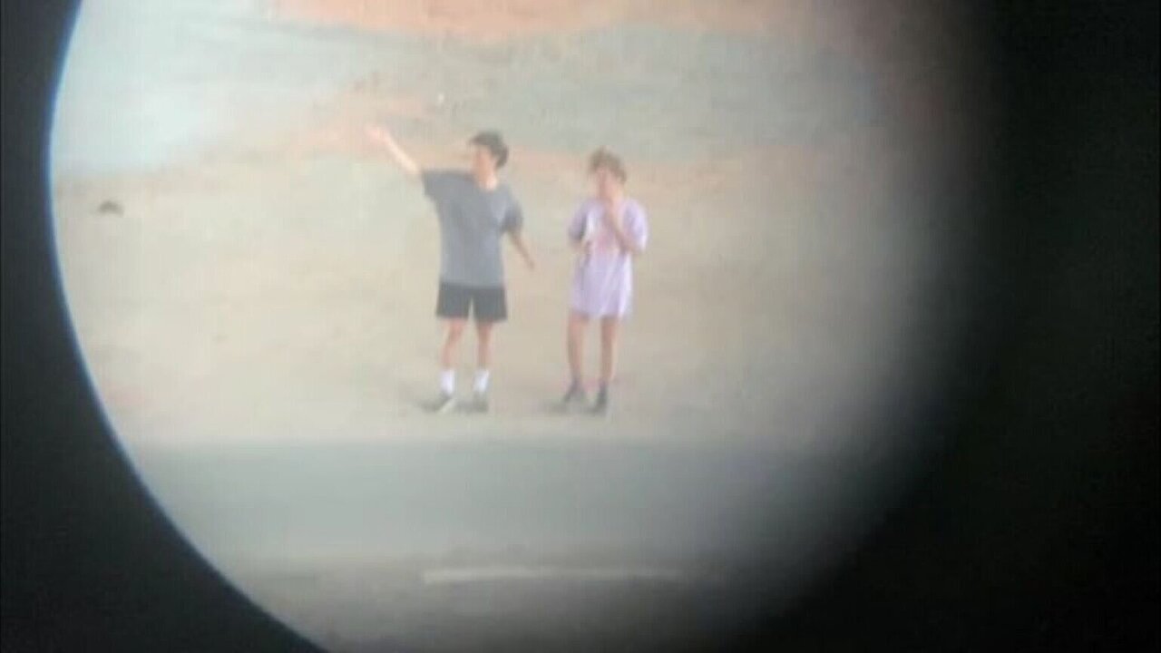 To figures im the distance, seen through a round opening.