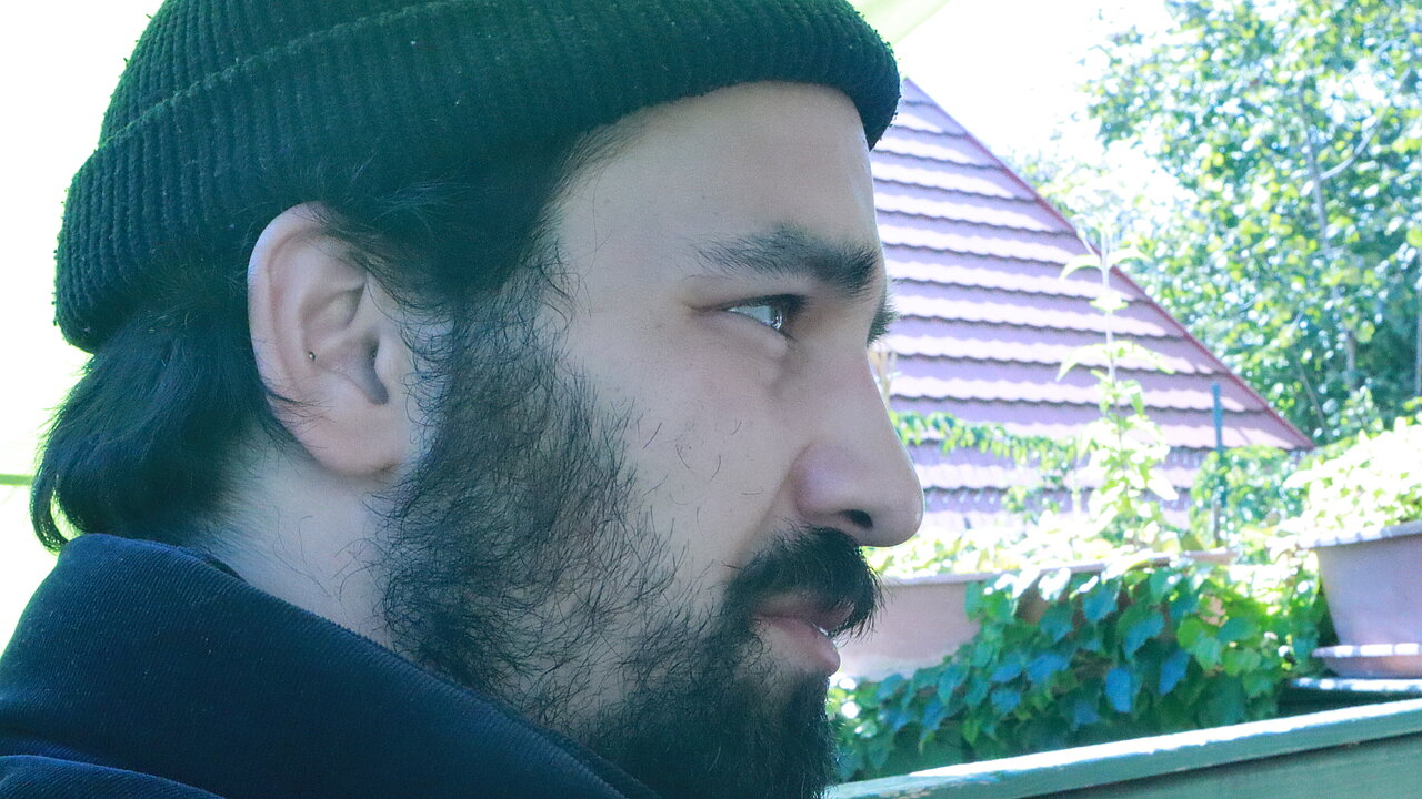 Portrait of Balázs Oláh from the side, with beanie