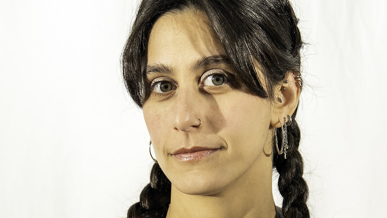 Portrait of Dominique Tegho, two braids, outgrown pony, a decent smile