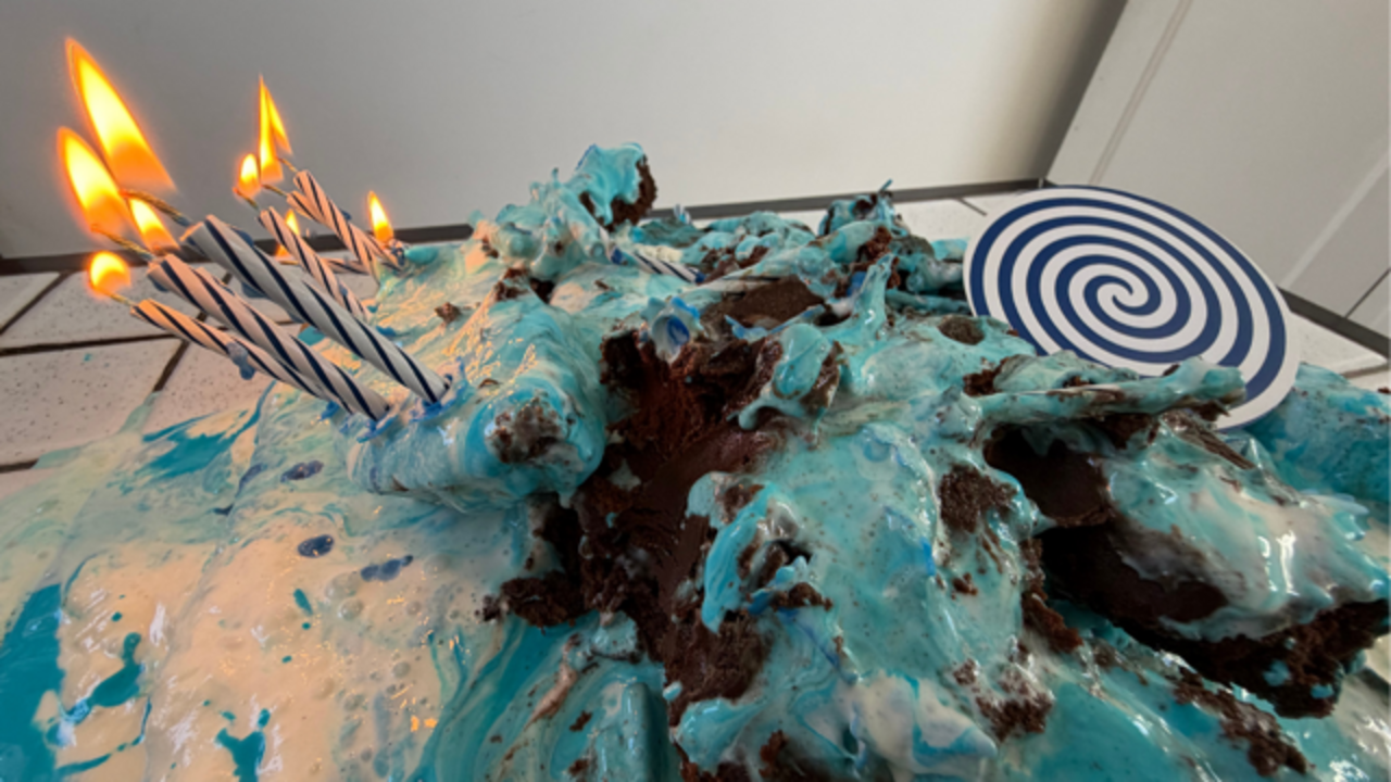 dangerously leaning to the side candles on a cake, burning.