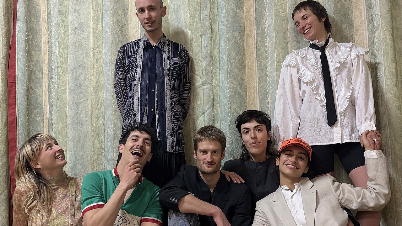 Production Xx standing in front of a grandma's curtain.