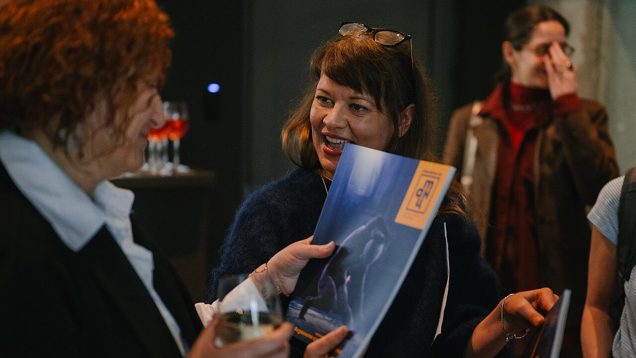 Angelina Georgieva happily handing over the magazine to someone.