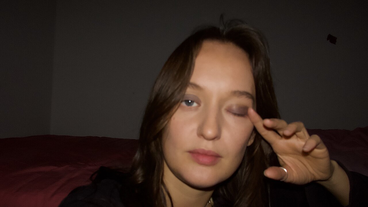 Portrait of Olivia Rivière, her finger above her closed left eye.