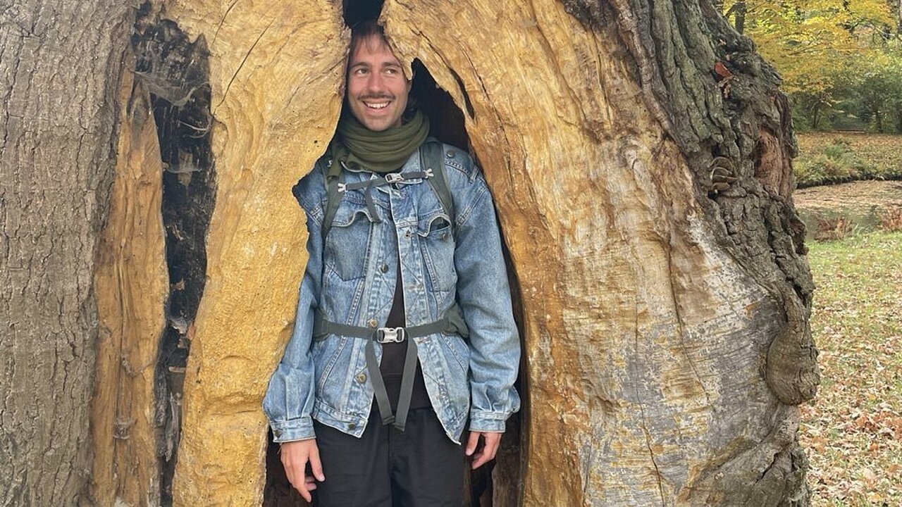 David Kummer standing inside a hollow tree