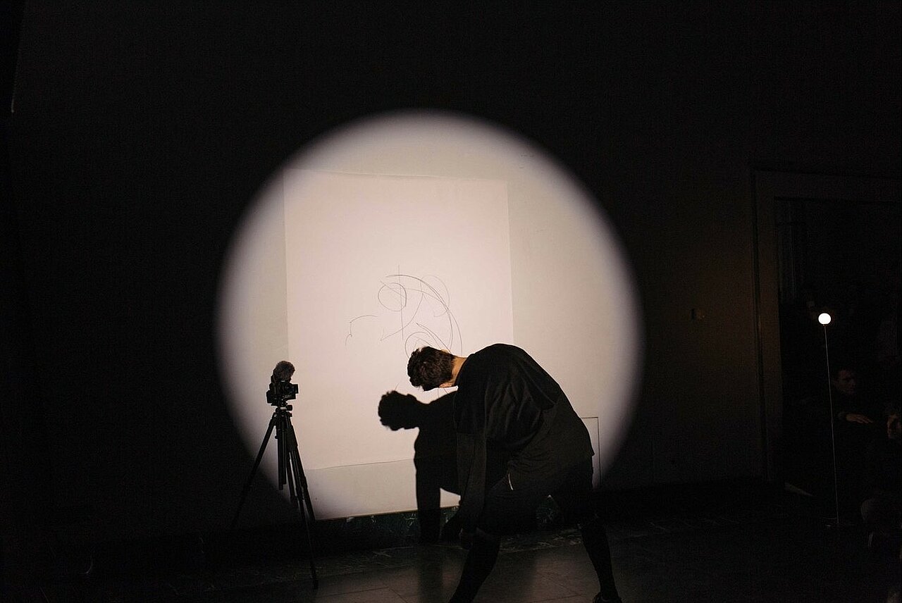 Man drawing on wall, seen from behind