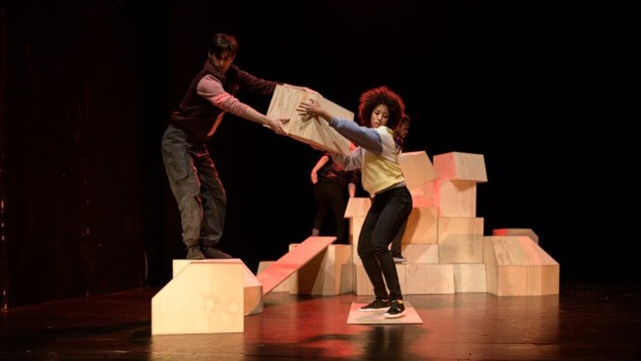 Tow performers next to a pile of wooden boxes.