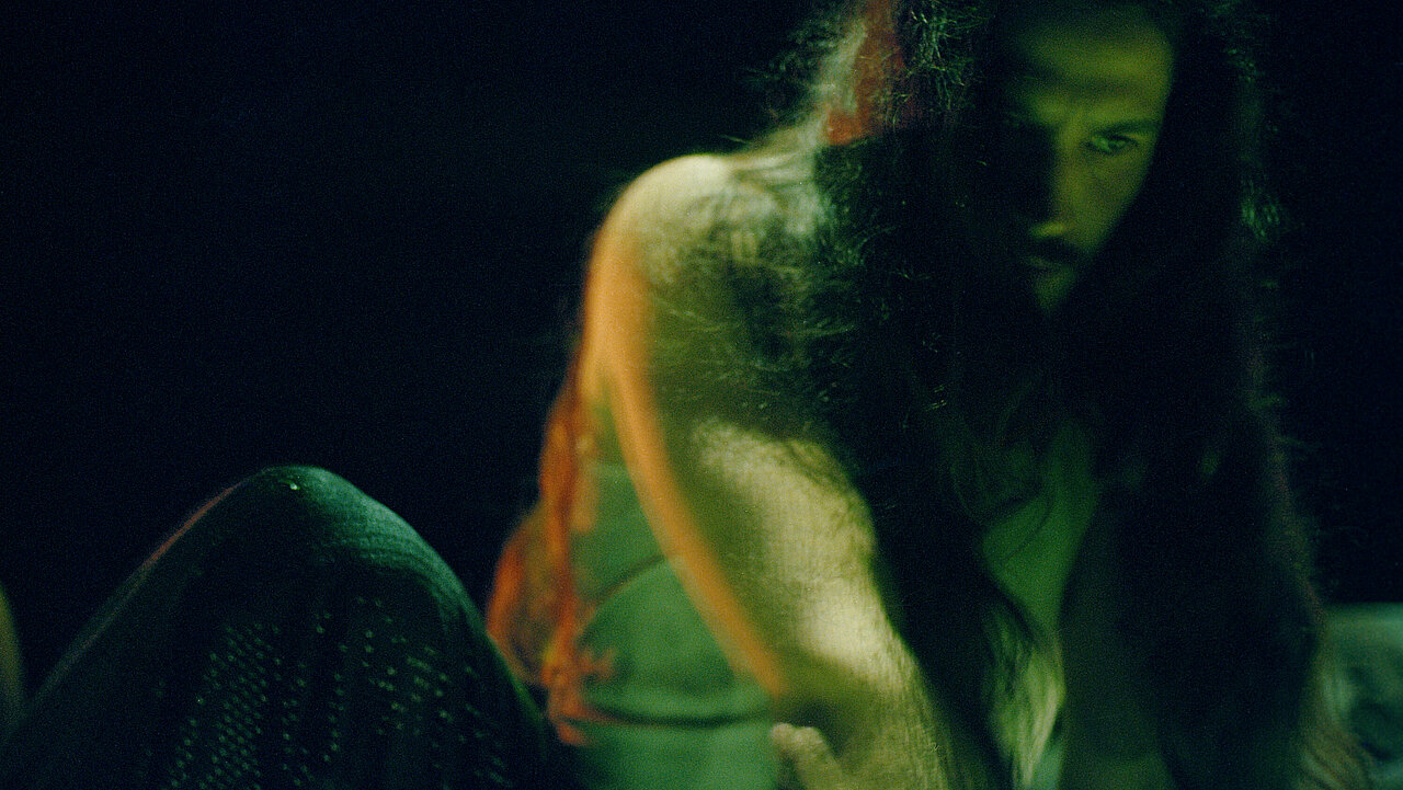 I Quit Ordinary Dancing by Viktor Szeri: Man with long hair coverng half of his face, leaning forward