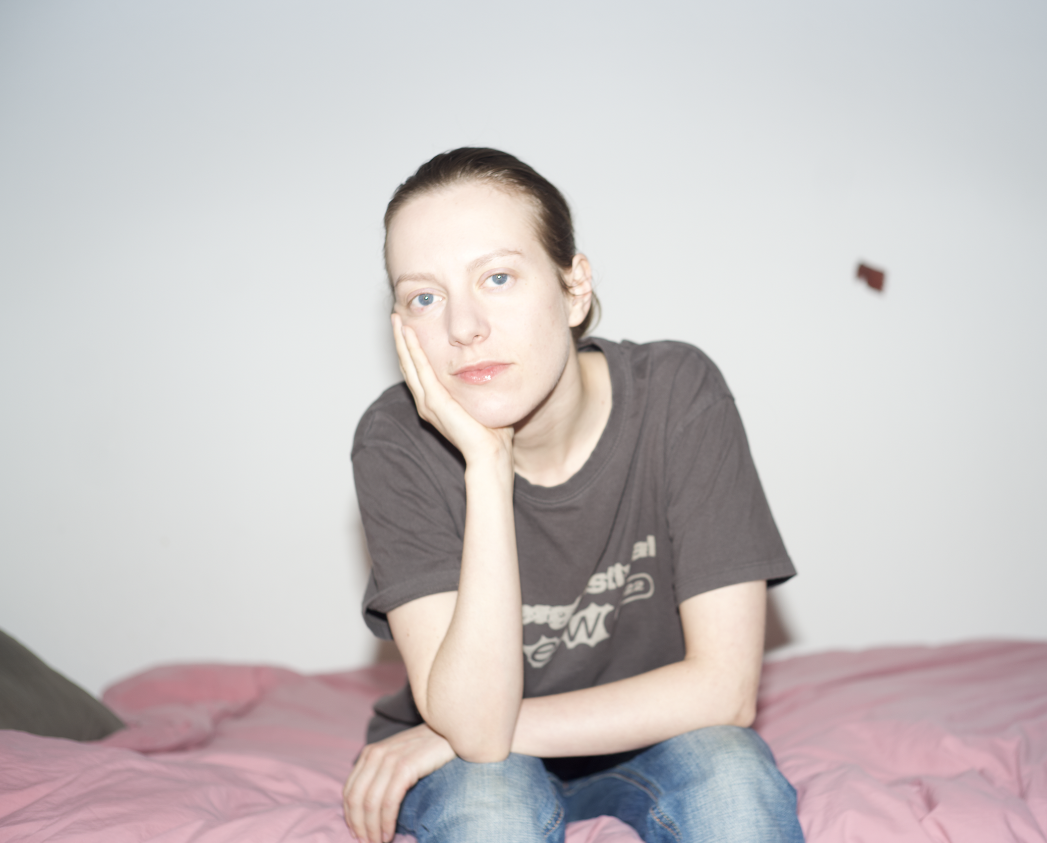 Portrait of Lisen Pousette, sitting on a bed, her head in her right hand